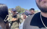 A security volunteer yells at a protester outside the Ashdod military cemetery on May 13, 2024. (Sam Sokol/Times of Israel)